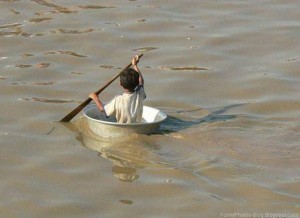 indian boy in steel bowl rowing